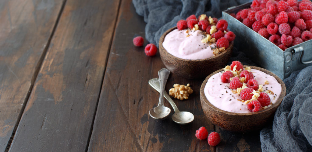 Raspberries smoothie bowls topped with fresh raspberries